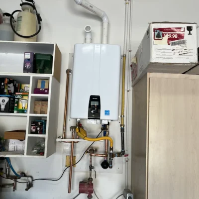 Wall-mounted tankless water heater providing on-demand hot water.
